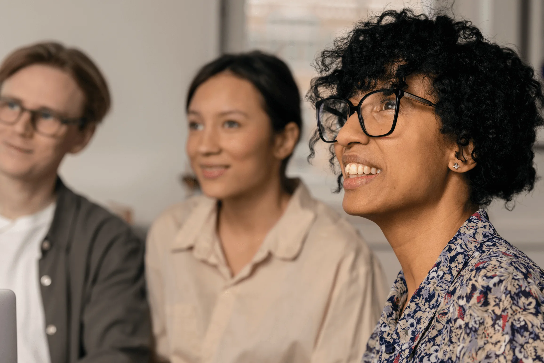 Engaged colleagues listening in a meeting where employee survey results shape the work environment